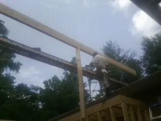 Carpenter setting a ridge beam over a new addition frame — Ice Dam Removal by Roofing Brothers in Daly City