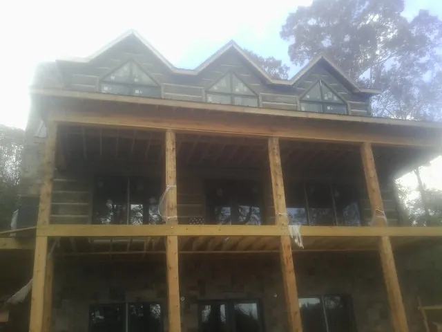 Dormers and porch framing on a large log home under construction — Roof Coating work by our crew in Daly City