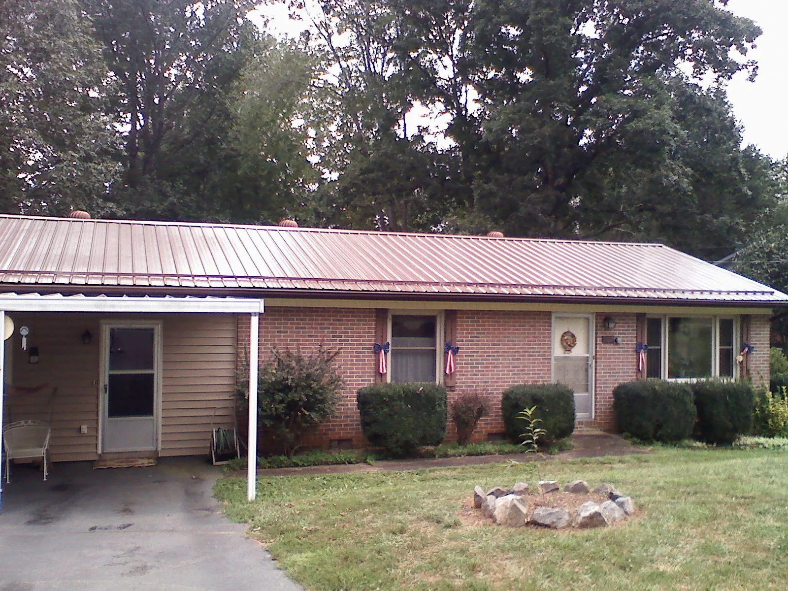 Bronze metal roof and carport on a brick ranch home — Roof Repair work by our crew in Daly City